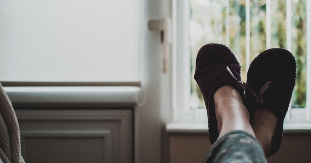 person-wearing-pair-of-cozy-black-slides