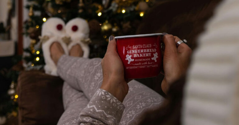 relaxing-by-the-christmas-tree-with-a-hot-drink-in-festive-pajamas-and-cozy-slippers